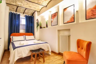 a bedroom with a bed and a chair at Paglia45 Apartment at Trastevere by Yourhost in Rome