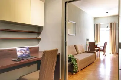 a living room with a table with a laptop on it at Paglia45 Apartment at Trastevere by Yourhost in Rome