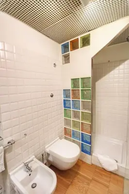 a white bathroom with a toilet and a sink at Paglia45 Apartment at Trastevere by Yourhost in Rome