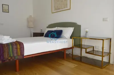 a bedroom with a bed and a side table at Oasis of Ample Space and Comfort in Rome