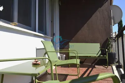 a pair of green chairs and a table on a balcony at Oasis of Ample Space and Comfort in Rome