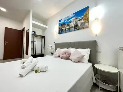 a bedroom with a white bed with two pillows on it at Vatican home in Rome