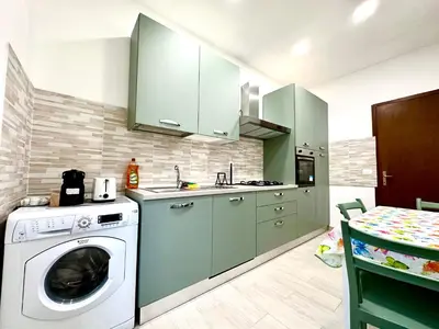 a kitchen with green cabinets and a washing machine at Vatican home in Rome