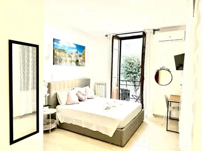 a white bedroom with a bed and a mirror at Vatican home in Rome