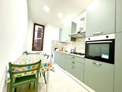 a kitchen with a table with chairs and a television at Vatican home in Rome