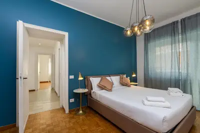 a bedroom with a large bed with a blue wall at Presidential Vatican Palace in Rome