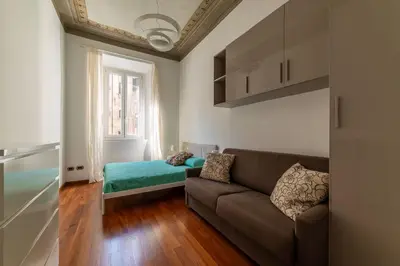 a living room with a couch and a bed at GuestHost - Vittorio Emanuele Elegant Apartment in Rome