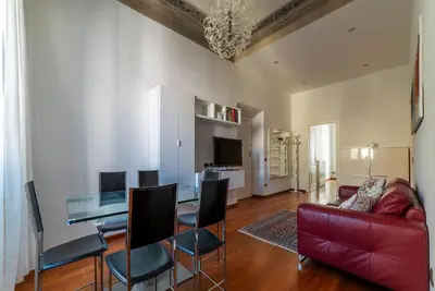 a living room with a red couch and a table at GuestHost - Vittorio Emanuele Elegant Apartment in Rome