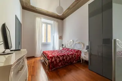 a bedroom with a bed with a red bedspread at GuestHost - Vittorio Emanuele Elegant Apartment in Rome