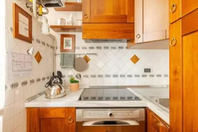 a kitchen with wooden cabinets and a stove top oven at Cristina's Home in Rome