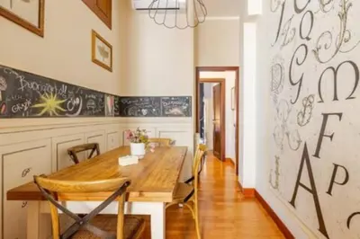 a dining room with a wooden table and a wall with graffiti at Cristina's Home in Rome