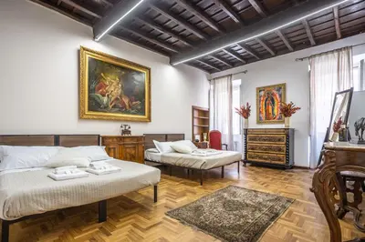 a room with two beds and a painting on the wall at sacra mysteria vatican in Rome