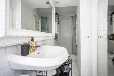 a white bathroom with a sink and a mirror at sacra mysteria vatican in Rome