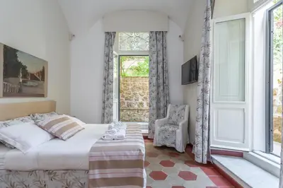 a bedroom with a bed and a window and a chair at Prati 3BDR Urban Charm in Rome