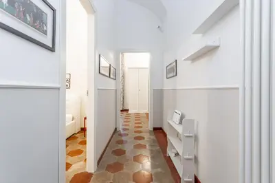 a hallway with white walls and a tile floor at Prati 3BDR Urban Charm in Rome