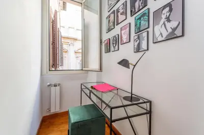 a room with a desk and a lamp and pictures on the wall at Eclectica Living by Navona Square in Rome