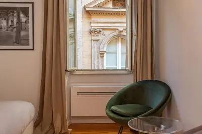 a green chair sitting in front of a window at Eclectica Living by Navona Square in Rome