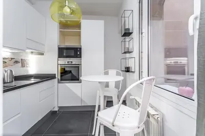 a kitchen with white cabinets and a table and chairs at Eclectica Living by Navona Square in Rome
