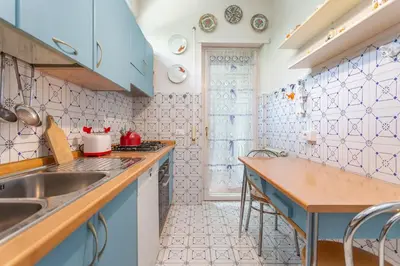 a kitchen with blue cabinets and a sink at St Peters Garden 3 BDR Apartment in Rome