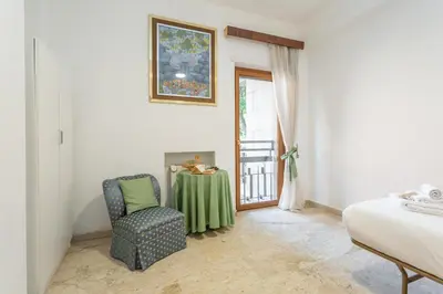 a bedroom with a table and a chair and a window at St Peters Garden 3 BDR Apartment in Rome