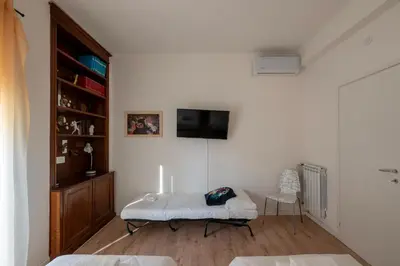 a white room with a bed and a tv on a wall at La casa a Cornelia in Rome