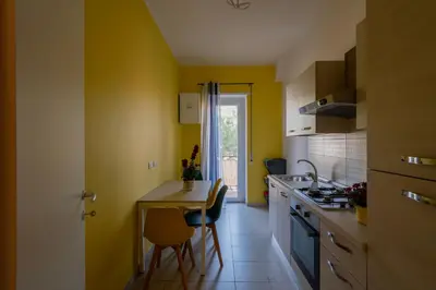 a kitchen with yellow walls and a table and a counter at La casa a Cornelia in Rome