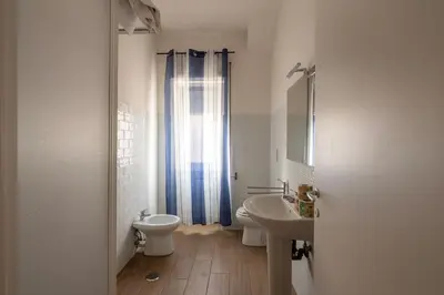 a white bathroom with a toilet and a sink at La casa a Cornelia in Rome
