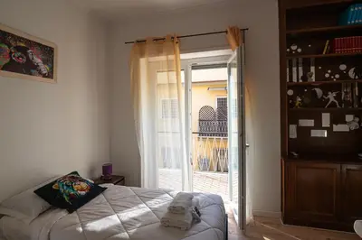 a bedroom with a bed and a sliding glass door at La casa a Cornelia in Rome