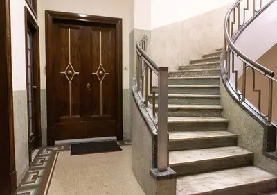 a set of stairs with a wooden door at Termini Alever apartament 3 bedrooms in Rome