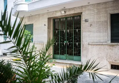 a building with a green door with a fence at Termini Alever apartament 3 bedrooms in Rome