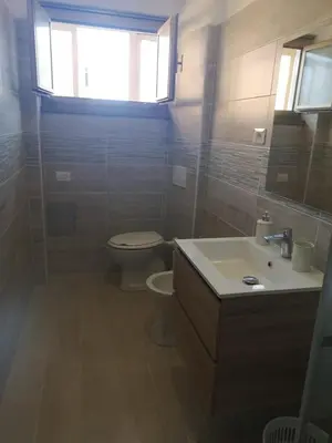a bathroom with a toilet and a sink and a window at Malatesta House in Rome