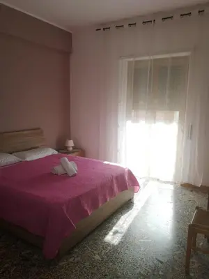 a bedroom with a bed with a purple blanket and a window at Malatesta House in Rome
