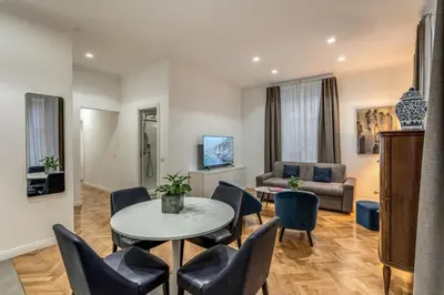 a living room with a table and chairs and a couch at Margana Apartment - Maison D'art Collection in Rome