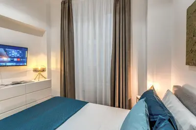 a bedroom with a bed with a tv and a window at Margana Apartment - Maison D'art Collection in Rome