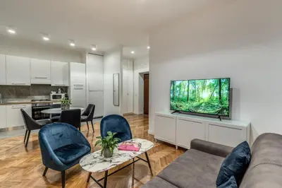 a living room with a couch and chairs and a kitchen at Margana Apartment - Maison D'art Collection in Rome