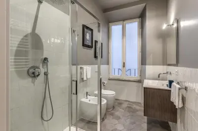 a bathroom with a shower and a toilet and a sink at Margana Apartment - Maison D'art Collection in Rome