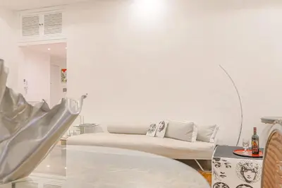 a white living room with a couch and a table at Piazza Navona Deluxe Apartment - Piano 2 Roma in Rome