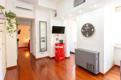 a room with a television and a clock on the wall at Casa Miso in Rome