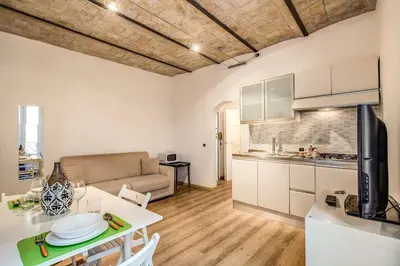 a kitchen and a living room with a table at Navona flat in Rome