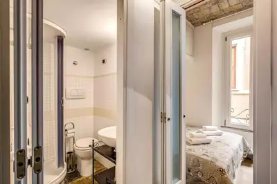 a white bathroom with a bed and a sink at Navona flat in Rome