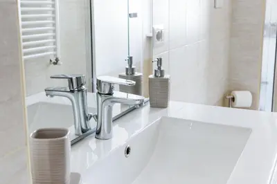 a bathroom sink with two faucets and a mirror at EasySleep Vaticano in Rome