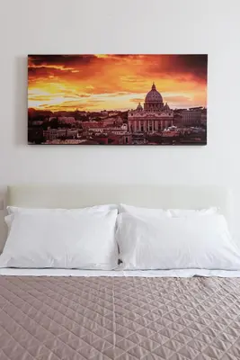 a bedroom with a bed with a painting on the wall at EasySleep Vaticano in Rome
