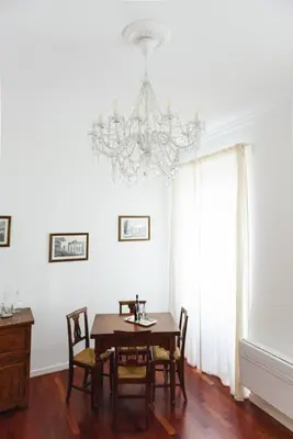 a dining room with a table and a chandelier at EasySleep Vaticano in Rome