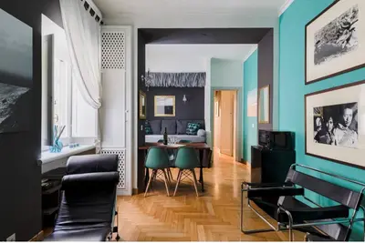 a living room with blue walls and a table and chairs at Suite Design Piazza di Spagna in Rome