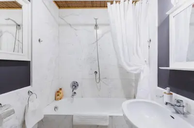 a white bathroom with a tub and a sink and a tubermottermott at Suite Design Piazza di Spagna in Rome