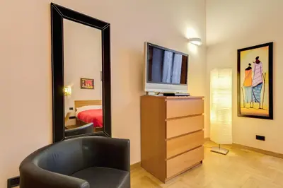 a room with a mirror and a chair and a television at Diamond Apartments in Rome