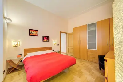 a bedroom with a red bed and a desk at Diamond Apartments in Rome