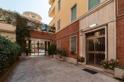 an empty alleyway between two buildings with plants at GuestHost - Piazza Bologna Sweet Apartment in Rome