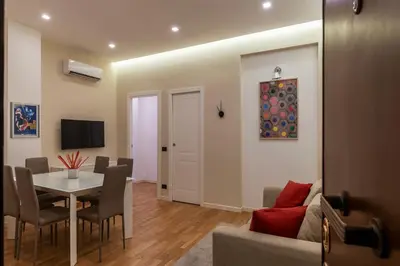 a living room with a dining room table and a couch at GuestHost - Piazza Bologna Sweet Apartment in Rome