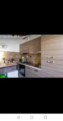 a large kitchen with wooden cabinets and appliances at Il Giardino del Borgo in Rome